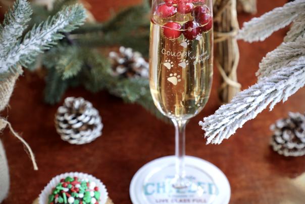 A glass of sparkling wine decorated with christmas motifs