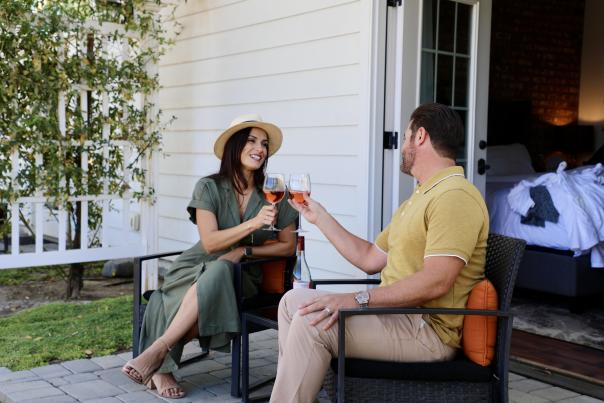 A couple sitting on a porch, enjoying a glass of wine
