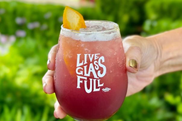 A branded stemless glass that reads "Live Glass Full"