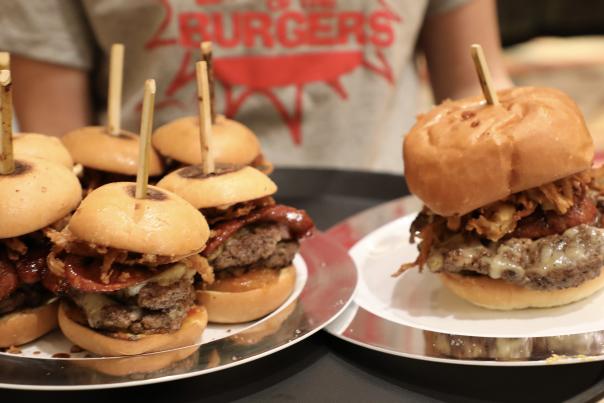 Waiter holding a tray with five burgers