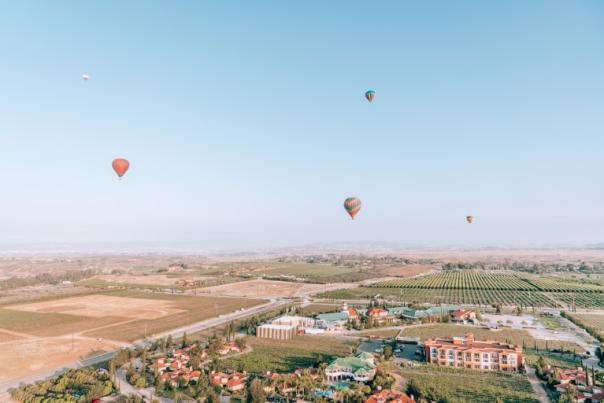 Aerial view of the Temecula Valley with several hot air balloons in the sky