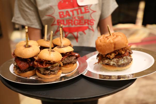 A waiter holding a tray of burgers