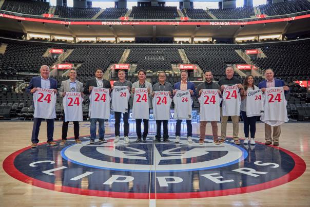 Several Pechanga and Los Angeles Clippers exectuvies pose while holding basketball jerseys