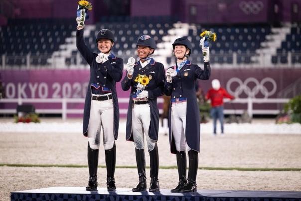 Three equestrians pose during the Tokyo Olympics
