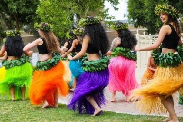 A group of women dancing in Hawaiian outfits
