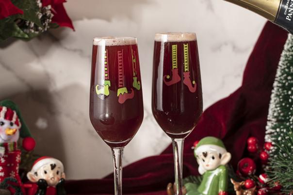 Tow glasses of sparkling wine surrounded by christmas decor