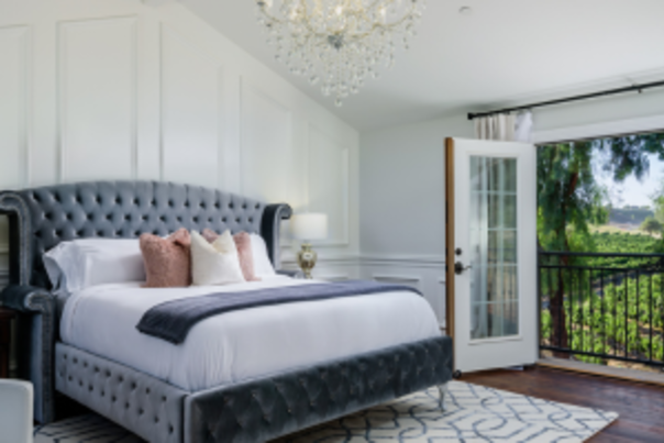 interior of a room at the vine house, close up of the bed and balcony with vineyard views