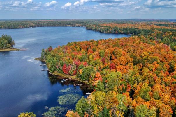 Aerial Photo of a lake and fall foliage in red orange yellow and green