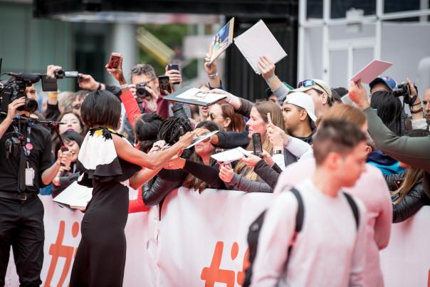 An actress signs autographs for fans at the Toronto International Film Festival