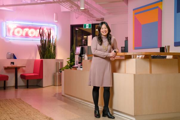 Eva Wong standing at Borrowell office with Toronto neon sign in background