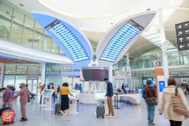 Toronto Pearson International Airport Interior with people walking and flight screens in the centre