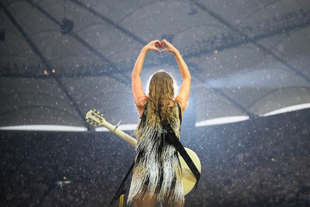 Taylor Swift during the Eras Tour showing a heart with her hands