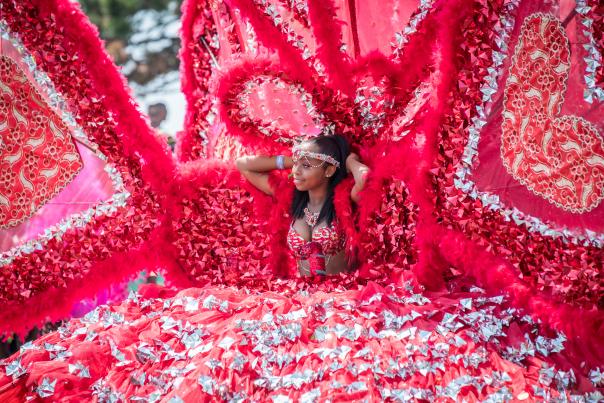 A woman in an incredibly elaborate red dress with heart motifs for the Toronto Caribbean Carival