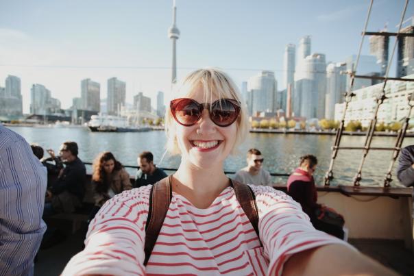 Person on boat with city skyline in the background along Toronto Waterfront