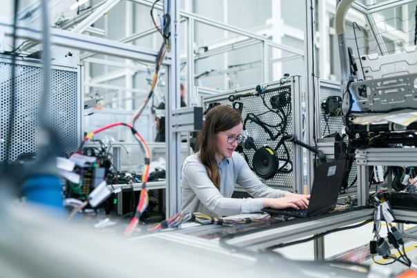 Woman seating in engineer lab testing equipment in front of a computer