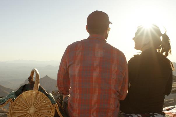 Couple sitting on top of a mountain