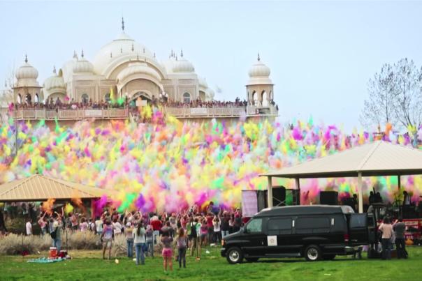 Large group of people throwing colorful chalk at the Krishna Temple in Spanish Fork for the Holi Festival of Colors
