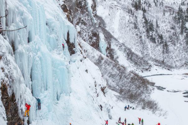 View of colorfully clothed ice climbers at the Frozen Bridal Veil Falls during the Annual Ice Fest