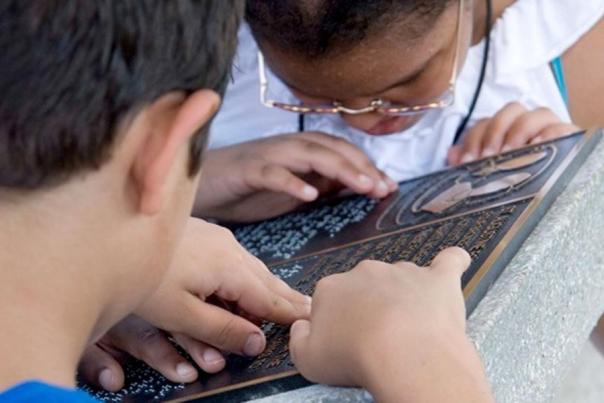 Blind kids read braille on one of the statues around St. Augustine's Plaza de la Constitución.