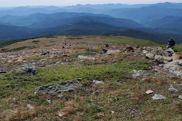 Panoramic Mountain Landscape with Cairns and Trail in Foreground