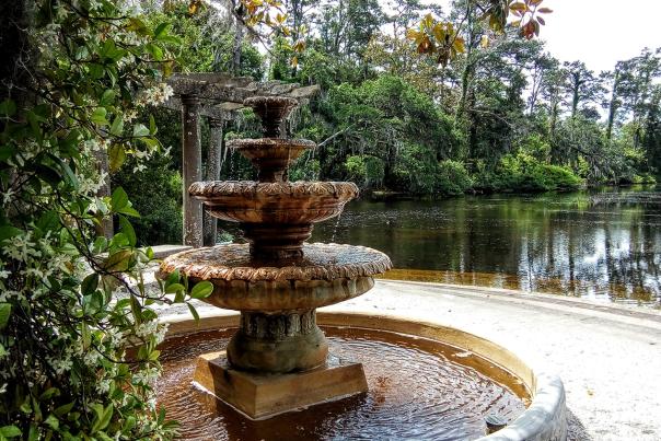 Surrounded by star Jasmine, a water fountain trickles next to a pond at Airlie Gardens