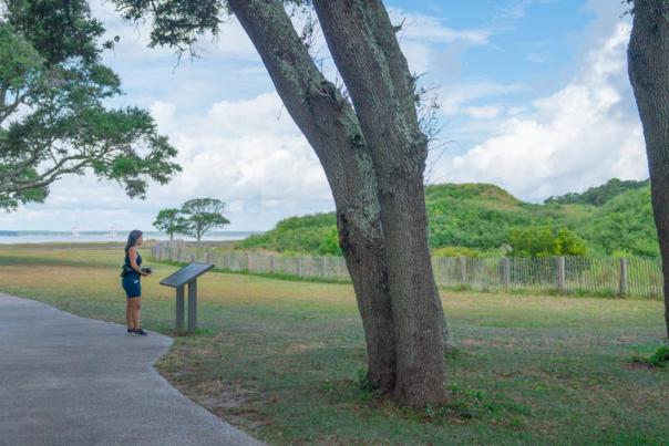 A woman reads an informational sign at Fort Fisher State Historic Site
