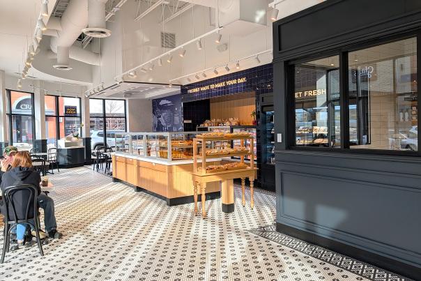 Inside of Paris Baguette bakery with couple seated at the left with sun shine splashing through the windows
