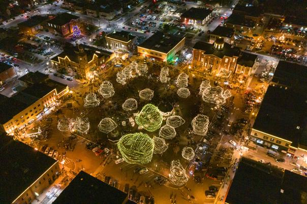aerial view of the Woodstock Square at the holidays, with white lights covering trees and buildings.