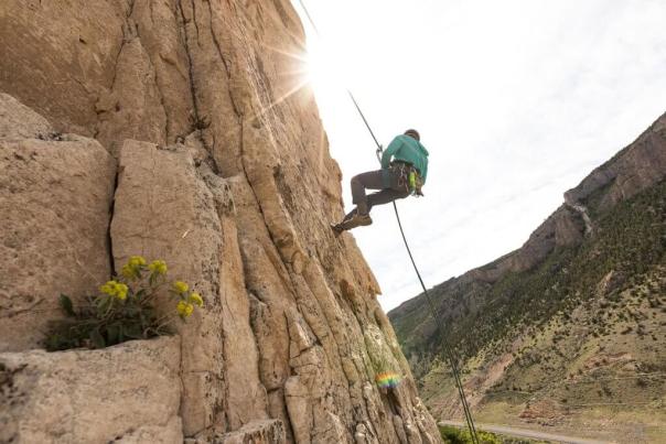 Rock climber repelling down route at Cody Bridge Bands in Wyoming