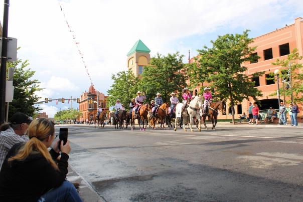 The streets of downtown Cheyenne come alive under a brilliant Wyoming sky as a sea of spectators, many clad in Stetson hats and denim, line the curbs for the Grand Parade. The air is thick with anticipation and the rhythm of clip-clopping hooves as historic horse-drawn carriages and riders in traditional Western regalia pass by. It is a vibrant tableau of community spirit, celebrating 'The Daddy of 'em All' with a mix of modern cheers and timeless frontier tradition.