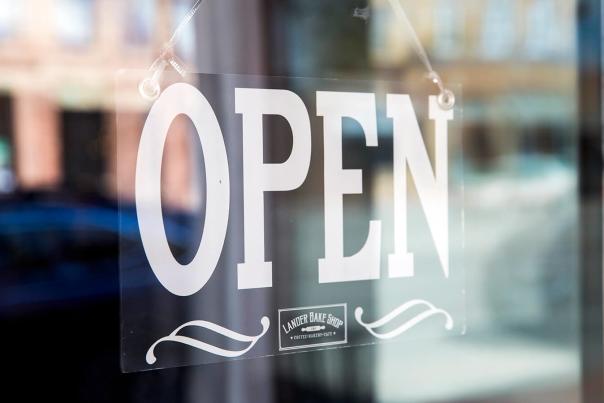 Open sign hanging inside of a window.