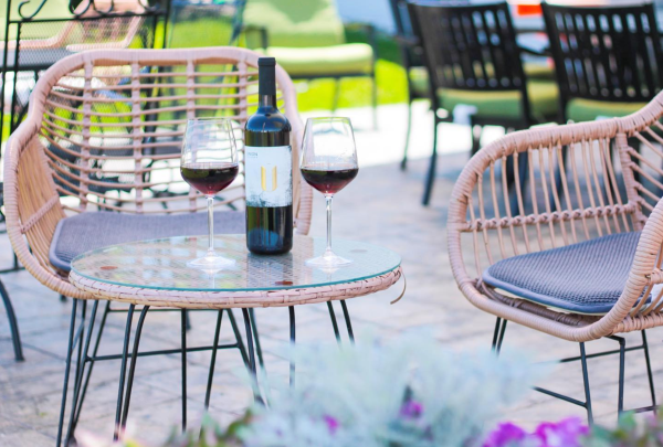 Union Cellars Winery Spring Patio with wine glasses filled next to an open bottle of refreshing wine