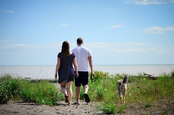 Couple and dog walking to beach