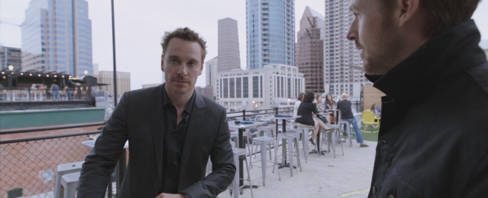 Song to Song screengrab showing Cook and BV talking on the rooftop at Neon Grotto bar overlooking downtown Austin