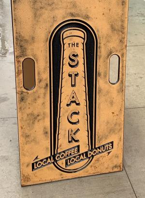 Rustic sign outside The Stack restaurant that reads "Local Coffee" and "Local Donuts"