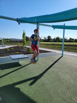 boy standing on a playground zipline