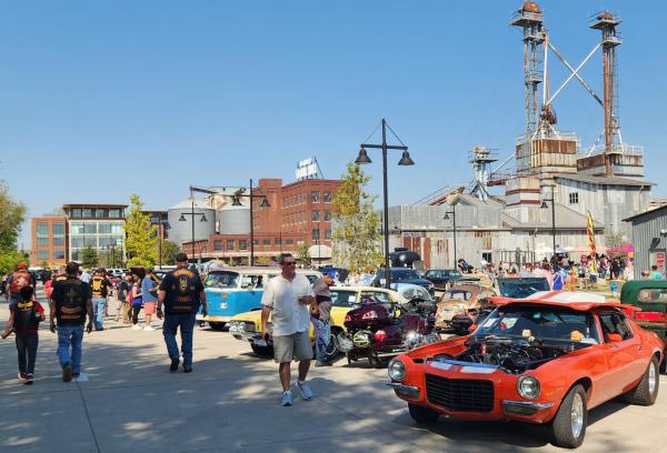 People walking through the parking lot at TUPPS Brewery looking at hot rods, ratrods, motorcycles, trucks and such.