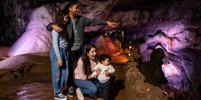 A family in a cave at Wookey Hole in Wells, near Bristol - credit Wookey Hole