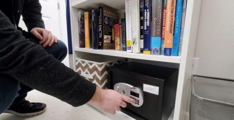 An escape-room player attempts to crack the safe in a room at Escape Room Virginia