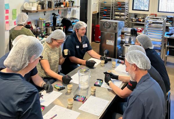 A group of people with hairnets make chocolate at Eldora Chocolate