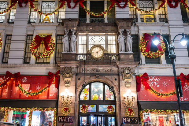 Macy's storefront adorned with holiday lights and decorations at night