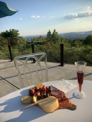 A charcuterie board on an outdoor table with a view at Burritt on the Mountain.
