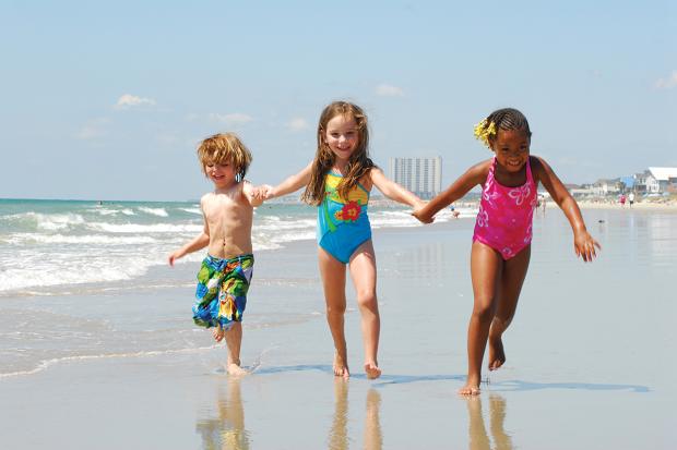 Three kids running on the beach, Myrtle Beach, SC