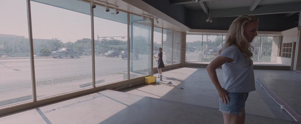 Song to Song screengrab, showing two women inside an abandoned building with a wall of glass windows