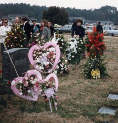 Graveside floral arrangement with three pink hearts
