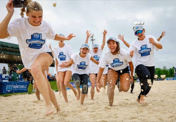 A Beach Volleyball Team cheering on the sand court