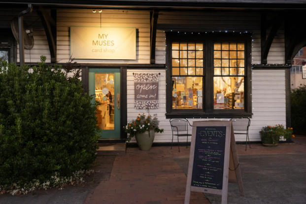 Outside view of My Muses Card Shop at night