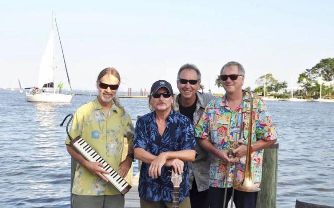 A group of musicians standing along the waterfront