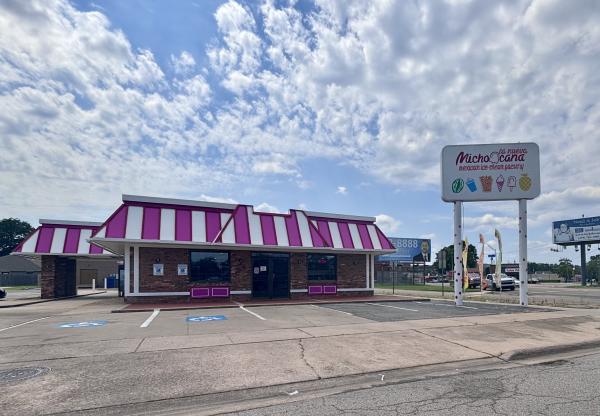 The exterior of La Michoacana featuring its iconic pink and white striped roof on a sunny day in Fort Smith, Arkansas.
