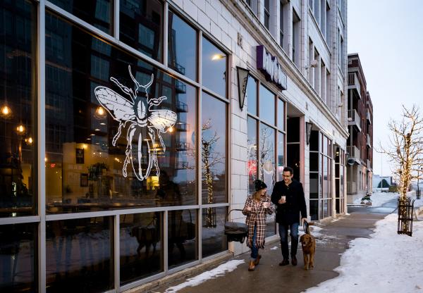 couple walking dog outside the Daily Buzz